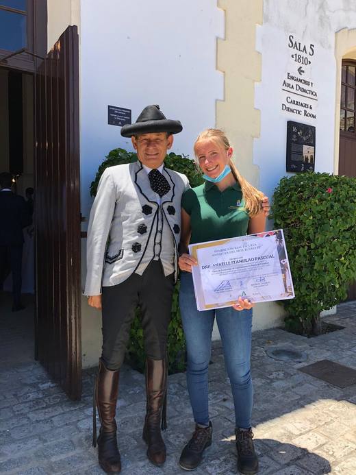 Rafael Soto, en tenue de gala de la Real Escuela, et Anaëlle Stanislao Pascual tenant son diplôme, devant la Sala 5.